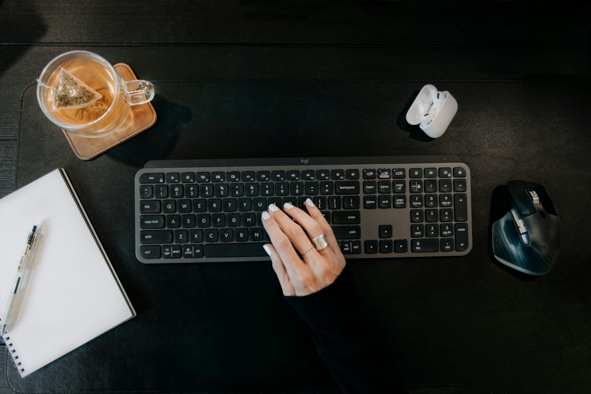 Un bureau d’écriture avec un clavier, un carnet et une tasse